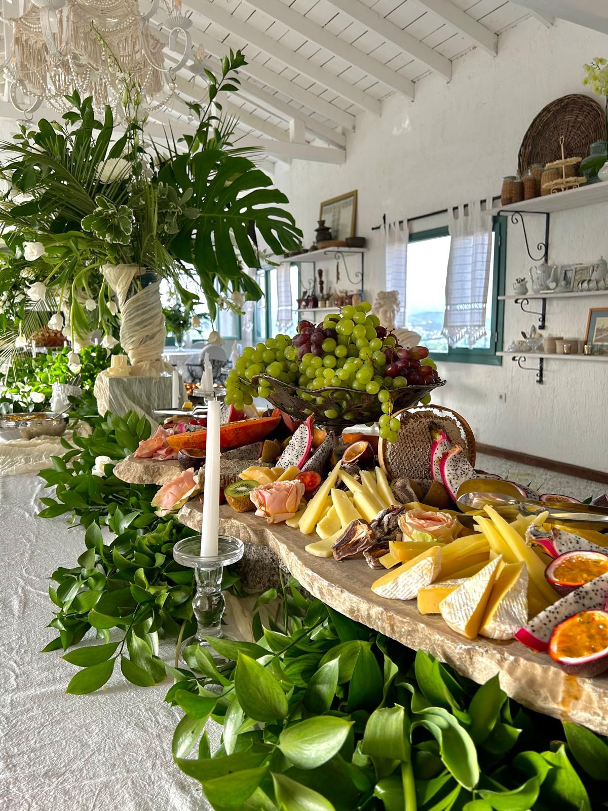 An abundant grazing table with fruit, cheese and greens