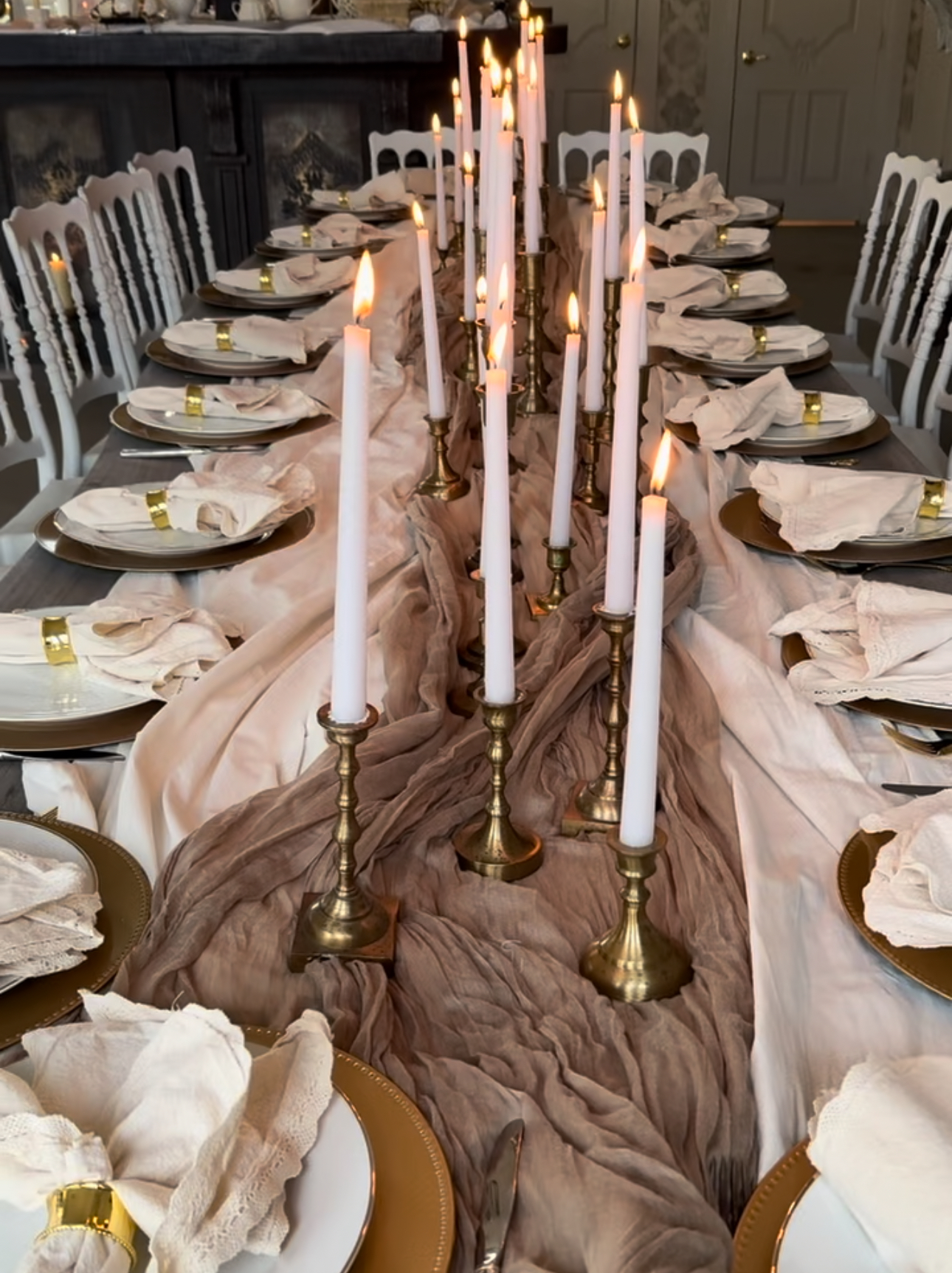 A candlelit long table dressed for dinner
